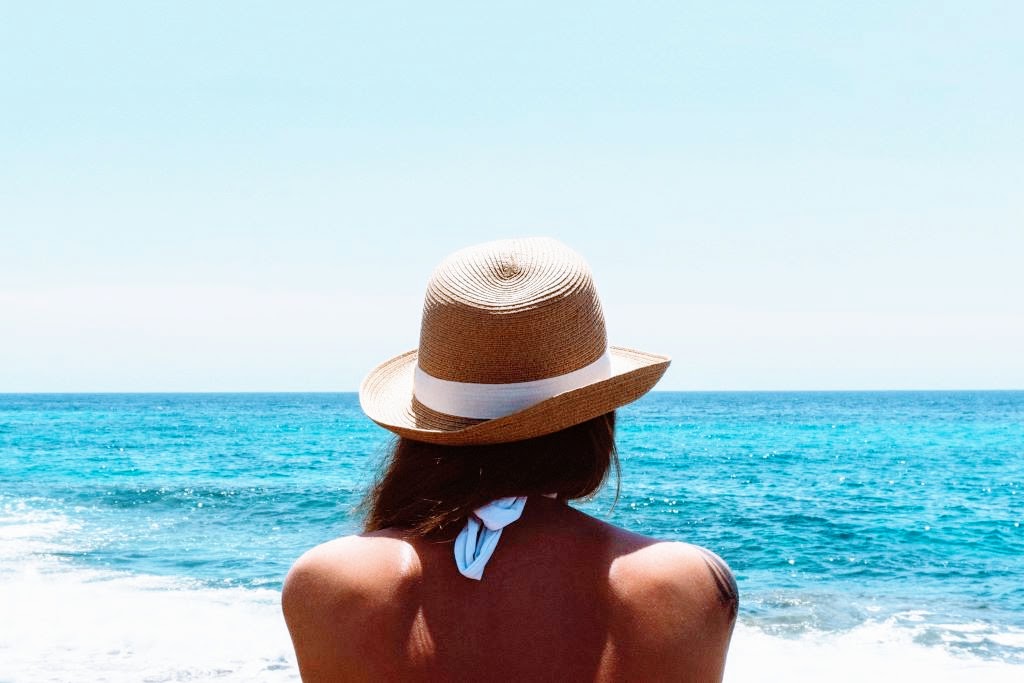 Woman standing on beach watching the ocean waves roll in